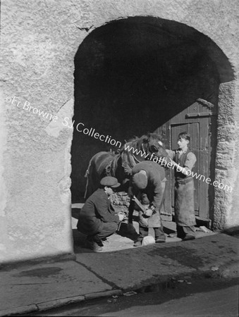 BLACKSMITH SHOEING HORSE